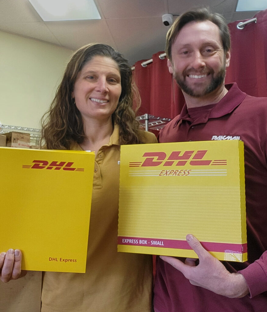 PakMail owners, Raelynn & Philip Jacobs holding DHL prepaid boxes.